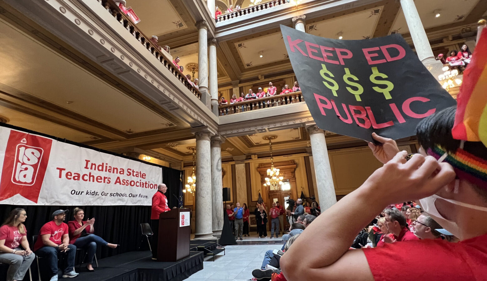 Inside the Indiana Statehouse, educators in red shirts carry protest signs as part of a Red for Ed protest.