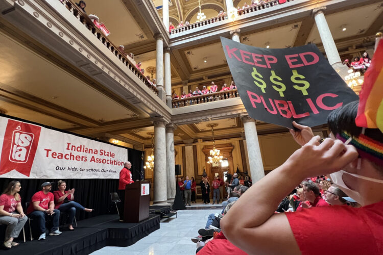 Inside the Indiana Statehouse, educators in red shirts carry protest signs as part of a Red for Ed protest.