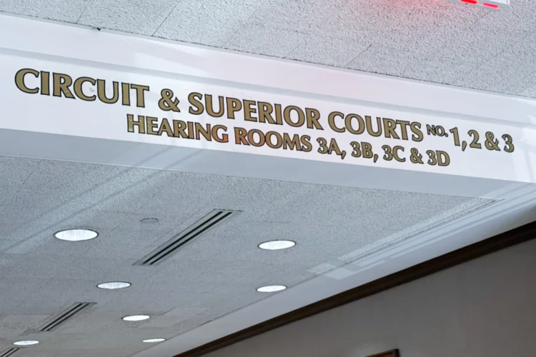 A narrow white sign attached to the roof. The words Circuit and Superior Courts printed on it