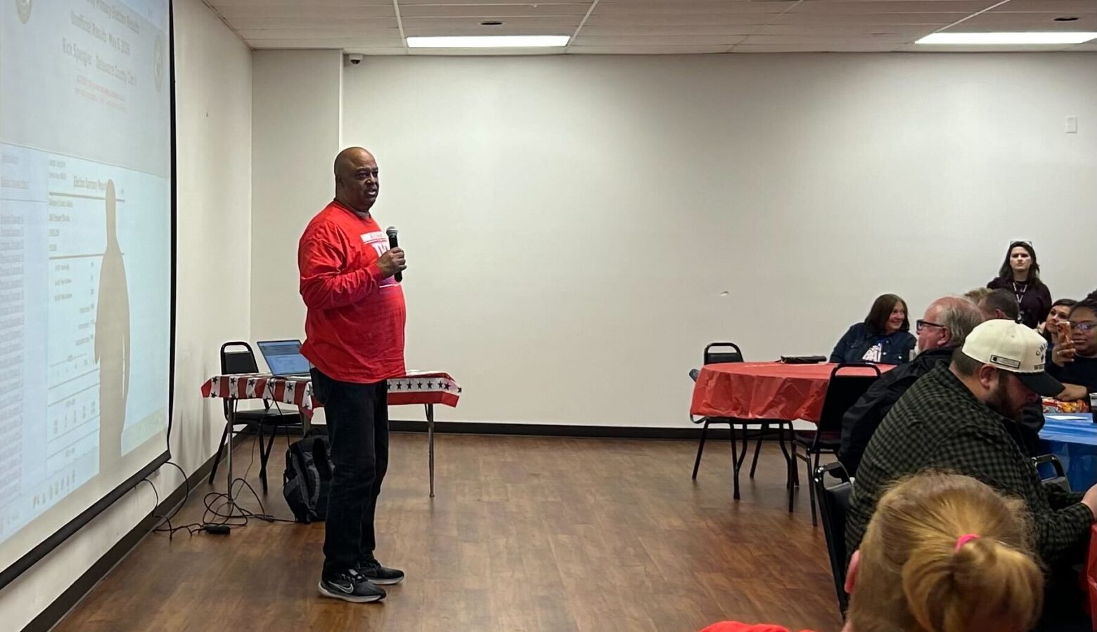 Richard Ivy, wearing a red campaign shirt, addresses an election night party.