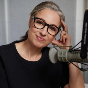 Portrait photo of Manoush Zomorodi, who is wearing glasses and sitting behind a microphone.