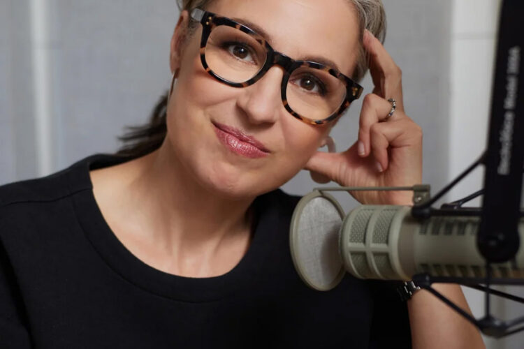 Portrait photo of Manoush Zomorodi, who is wearing glasses and sitting behind a microphone.