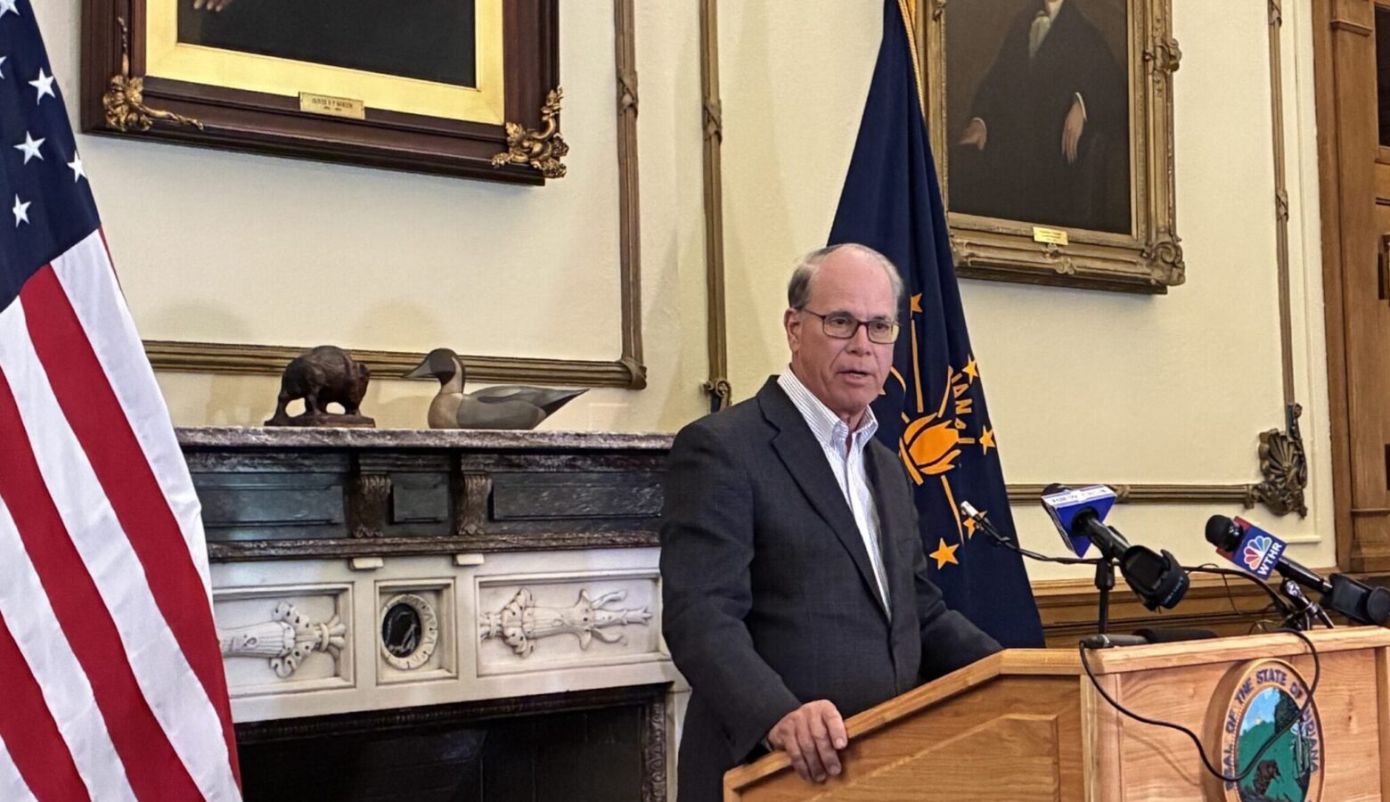 Indiana Governor Mike Braun speaks from his office, standing behind a podium with microphones.