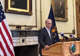 Indiana Governor Mike Braun speaks from his office, standing behind a podium with microphones.