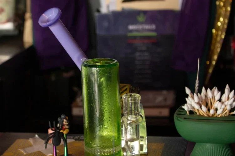 A dab rig sits on the bar inside of WildEye Cannabis, a cannabis consumption lounge in Indianapolis. A table holds a dispenser of pointed cotton swabs and a couple of small bottles.