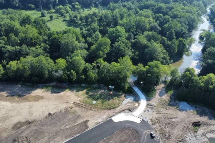 A birds-eye-view of a paved road leading to a river