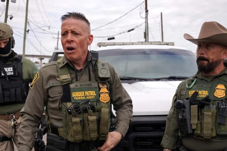 Former U.S. Border Patrol Commander Gregory Bovino stands with two border patrol officers.