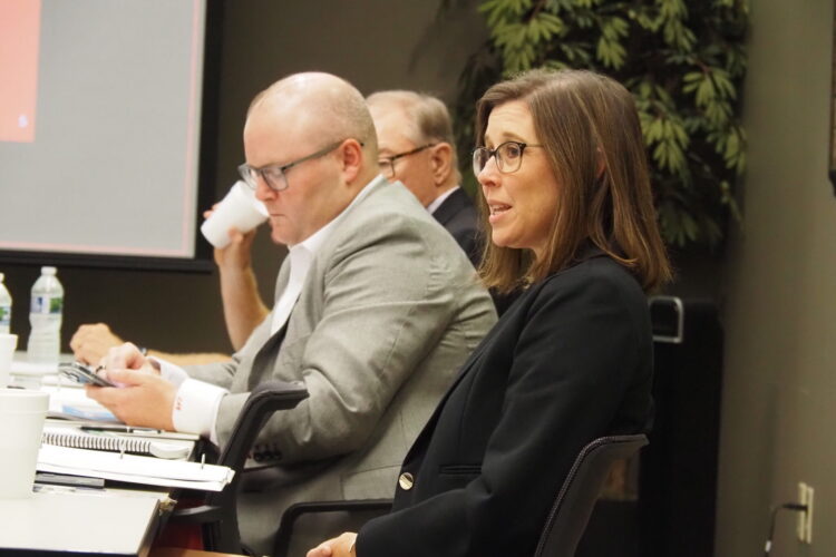 Hoosier Lottery commission members sit around a table, discussing the yearly revenue from the games.