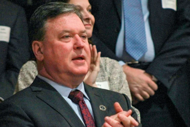 A closeup of Indiana Sec. of State Todd Rokita standing up in a crowd at what appears to be a meeting or a rally.