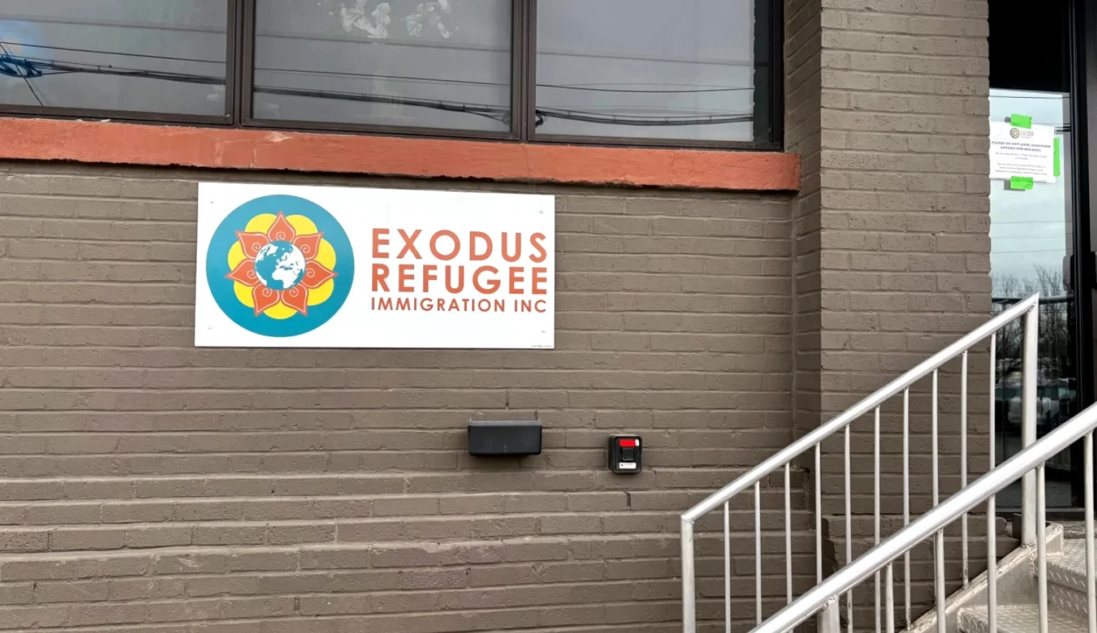 The side of a building with a sign for Exodus Refugee Immigration Inc