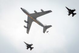 Three U.S. Air Force planes, as seen from below, fly across the sky.