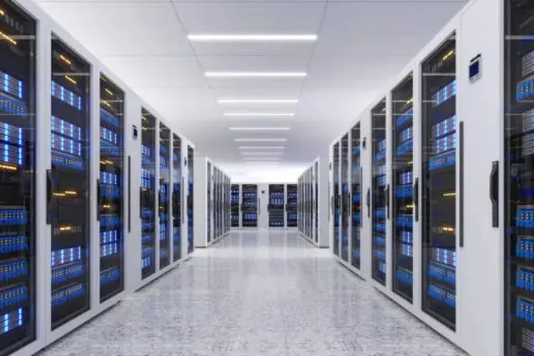 A clean, white hallway is lined with racks and racks full of servers and other digital components found in data centers.