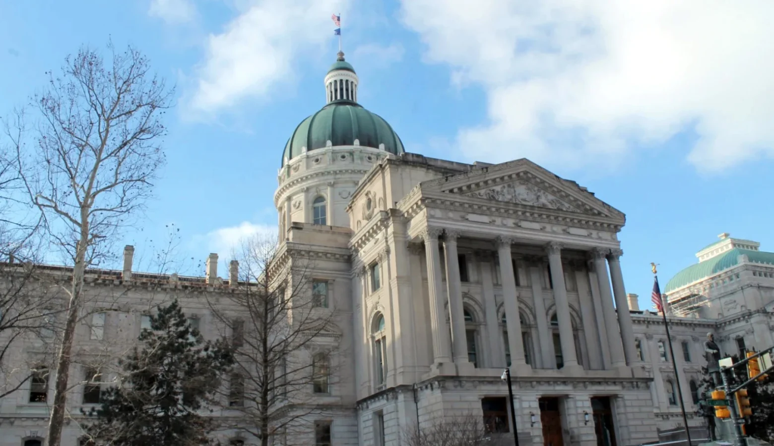 A photo of the east front of the Indiana Statehouse with a partly cloudy sky above it.