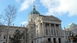 A photo of the east front of the Indiana Statehouse with a partly cloudy sky above it.