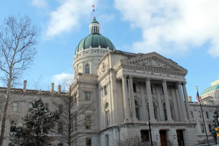 A photo of the east front of the Indiana Statehouse with a partly cloudy sky above it.