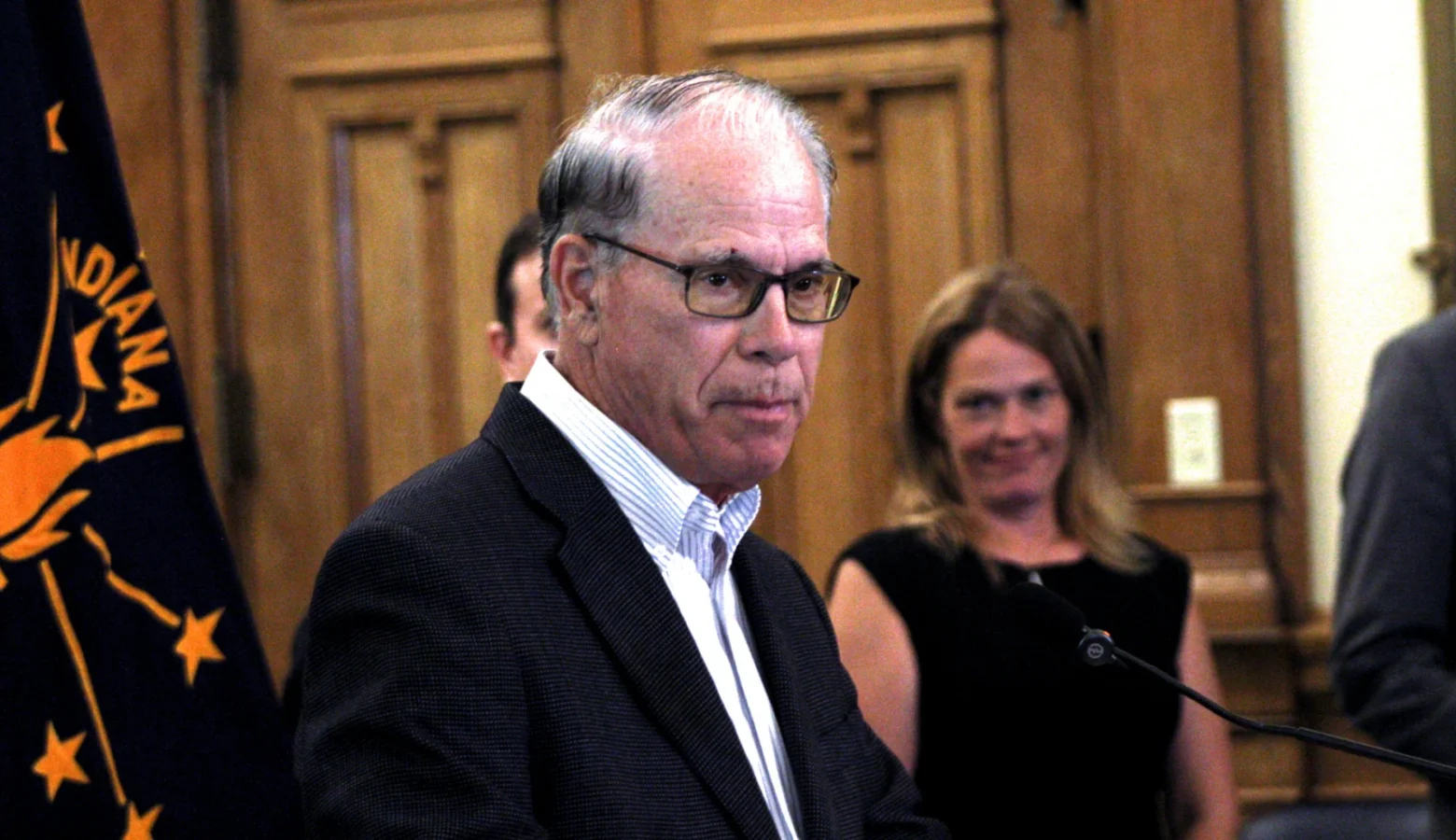 Governor Mike Braun is pictured in his office, with the Indiana flag behind him.