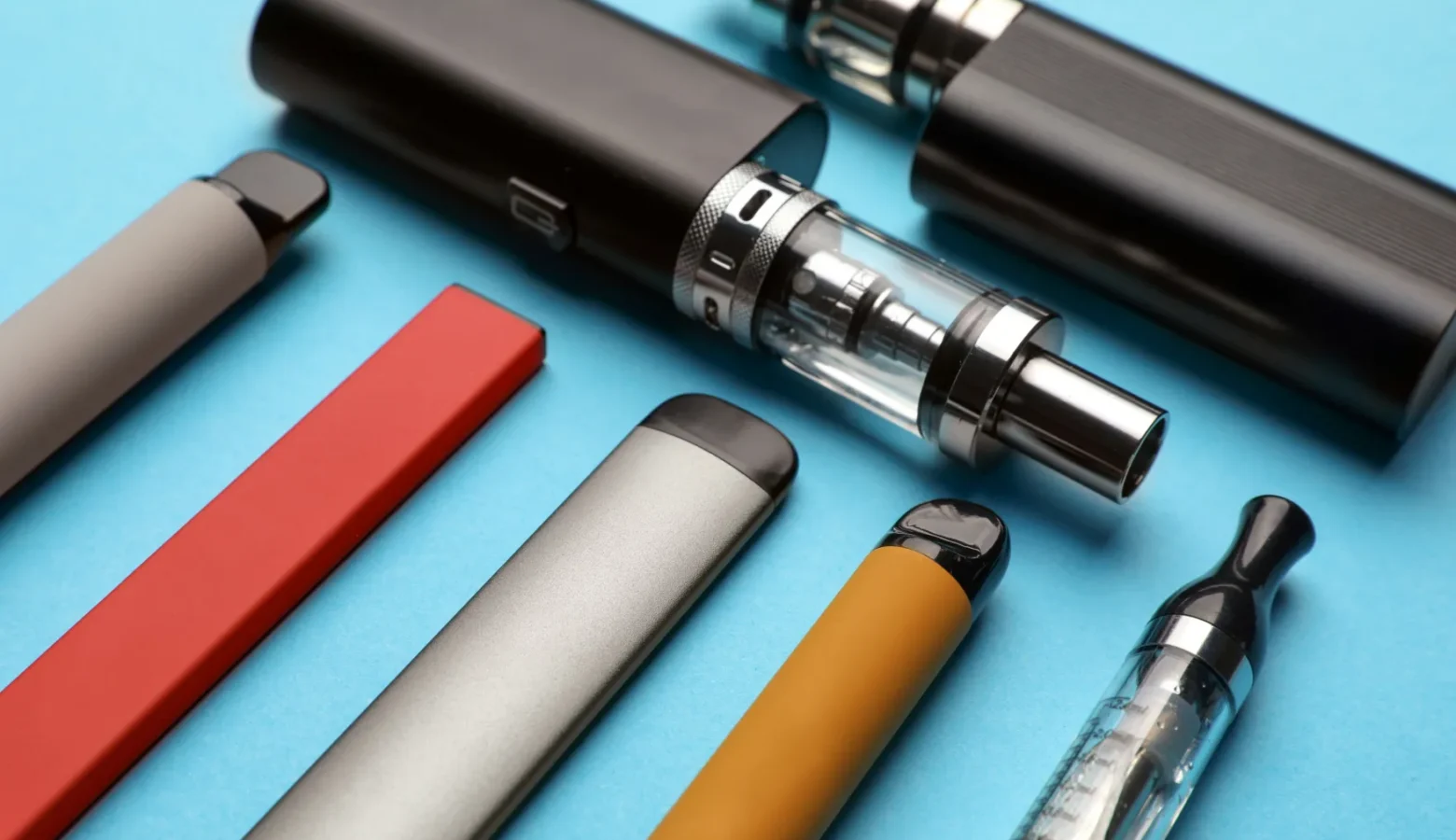 A collection of vape pens sit on a counter.