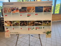 A poster board on an easel shows events that could be hosted in Muncie parks, including sports and community movie nights.