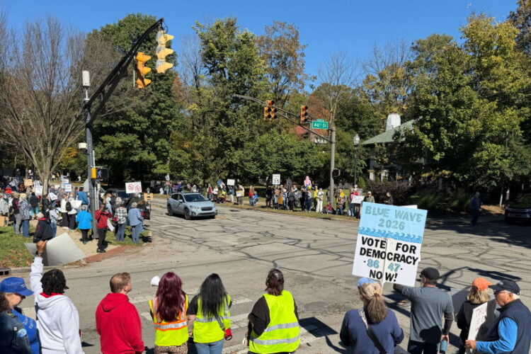 More than 100 people gathered outside the official residence of Gov. Mike Braun in Indianapolis, Sat., Oct. 17 for a "No Kings: Vote Early" rally urgins voters to turn out in the November midterm elections. The intersection of Meridian and 46th streets has protesters holding a variety of signs on sidewalks along the intersection on a sunny day.