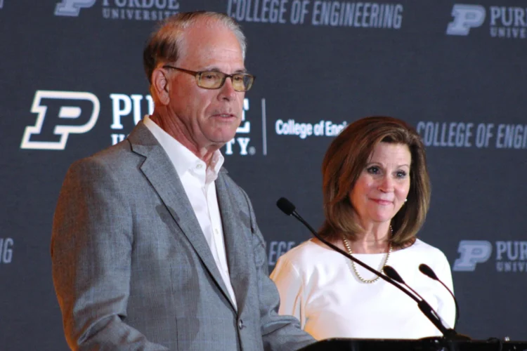 Gov. Mike Braun stands next to a woman. In front of them is a lectern with a microphone
