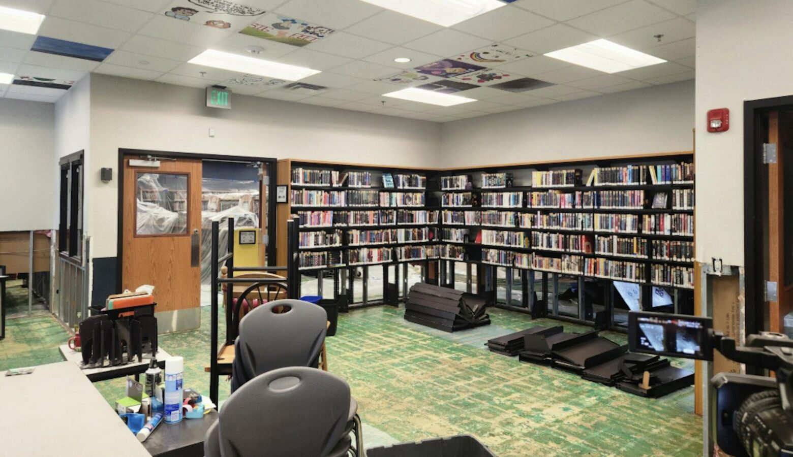 A room in a library includes bookshelves, desks, and chairs.