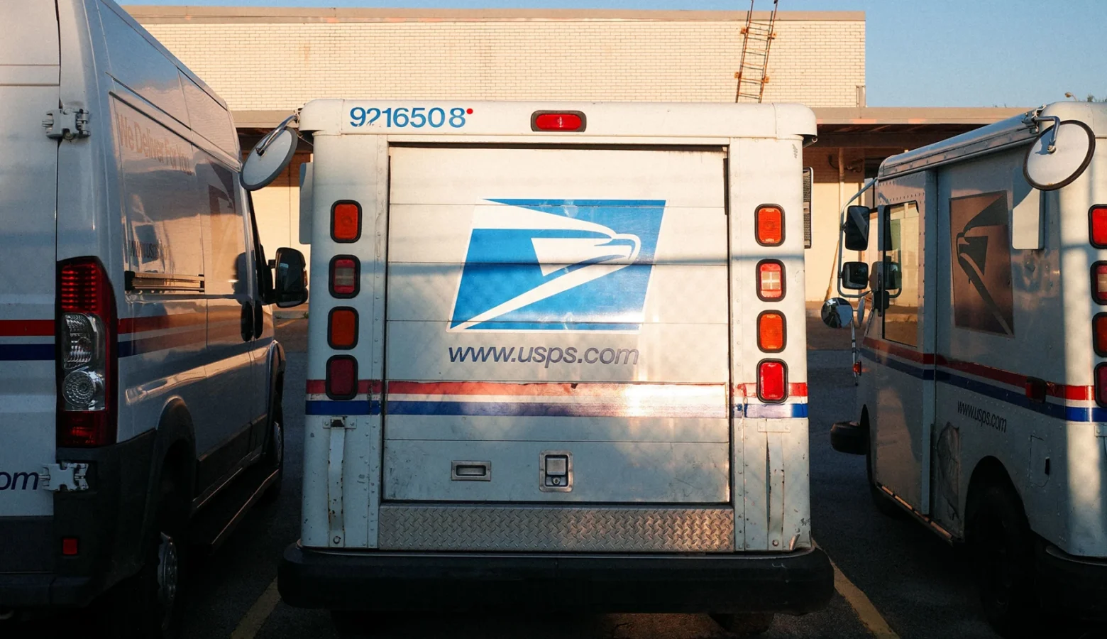 USPS vehicles parked in a row.